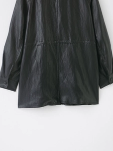 Detail view of the black leather jacket sleeve and hem featuring fine stitching and texture