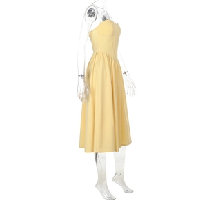 Detailed side view of the pleated waist and flared skirt on a yellow tube dress