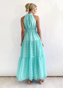 Detail of light blue checkered tiered maxi dress showing fabric texture and back design