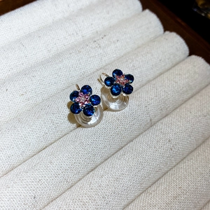 Close-up of blue floral rhinestone clip-on earrings with soft silicone padding