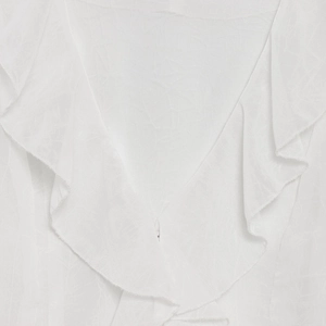 Close-up of elegant ruffled layers on a white V-neck blouse with lightweight fabric texture
