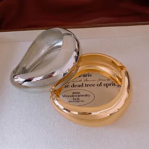 Irregular wide metal bracelets in gold and silver finish with polished mirror surface