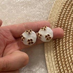 Detailansicht der runden Vintage-Emaille-Ohrstecker in Cremeweiß und Gold mit Blumen