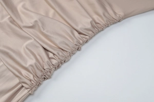 Gros plan détaillé sur un tissu en soie doré champagne avec des plis élastiques élégants