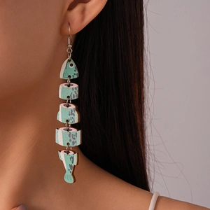 Detailed view of stylized fish bone earring with teal wood grain finish on female model