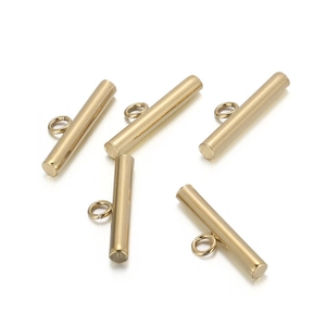Macro detail of five gold stainless steel toggle clasps for jewelry making on white background