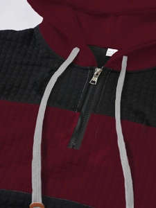 Detail of color-block hoodie showing quilted texture, silver zipper and S size label