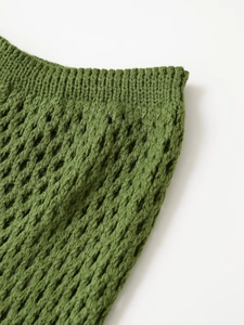 Close-up of green hand-knitted crochet mesh texture on this vacation style garment