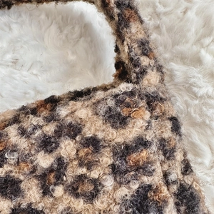 Close-up of leopard print faux shearling fabric texture on a fuzzy winter tote bag