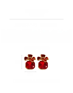Detail of vintage square earrings with red rhinestones and golden bow accents