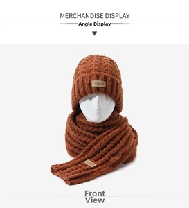 Dettaglio della trama a treccia e etichetta in pelle su questo set sciarpa e cappello