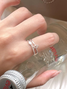 Close-up of stacked S925 sterling silver fish tail rings with pave zirconia on hand