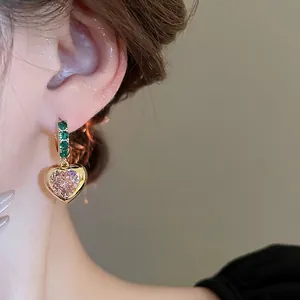 French style heart earrings with emerald green zircons and pink pave crystals on model