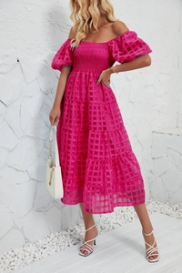 Detail of smocked bust and puffy sleeves on a tiered pink textured summer dress
