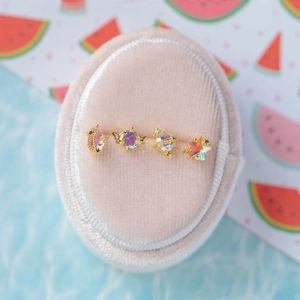 Close-up of gold stud earrings with iridescent gemstones in moon and star shapes