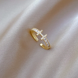 Adjustable gold plated H ring with cubic zirconia on champagne silk background