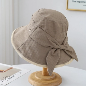 Detailansicht Khaki Sonnenhut mit großer Schleife und Metallemblem auf Hutständer