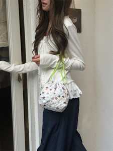 Lifestyle detail of a quilted cartoon drawstring storage bag with lime green cords.