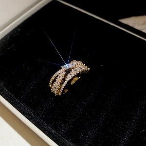 Detailed view of luxury gold-plated cross ring with sparkling baguette-cut zircons