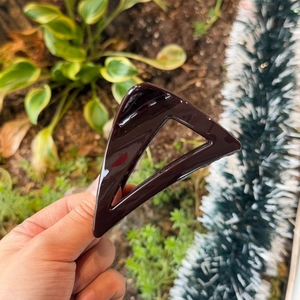 Detail of a large 8cm deep purple triangular hair claw clip with glossy finish