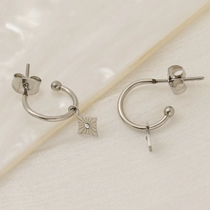 Silver C-shaped stainless steel earrings featuring star charms with inset crystal detail