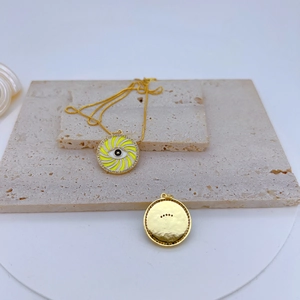 Detail of gold-plated pendant with yellow spiral eye pattern and zircon halo