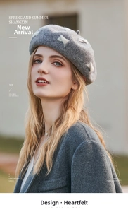 Detail of grey wool beret featuring elegant white bow pattern with warm winter texture