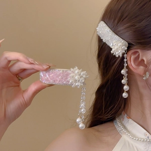 Detail view of flower hair clip with dangling pearl tassels and sparkling rhinestones