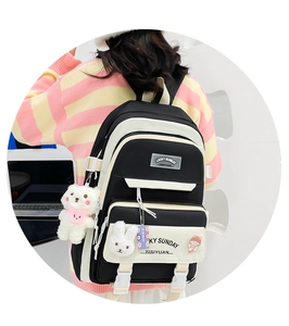Detailed view of large capacity school backpack with plush pendants and cute badges