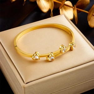Detail of a gold-plated titanium steel hinge bracelet with four heart-shaped zircons