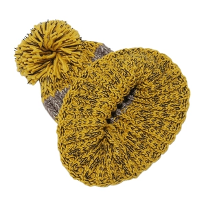 Close-up of thick ribbed knit mustard yellow and grey beanie with a large fluffy pom-pom