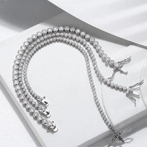 Three sizes of silver tennis chains with round zircons on white geometric pedestals