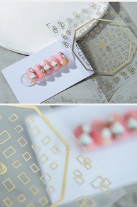 Macro detail of gold geometric nail art stickers featuring square and rectangular line patterns