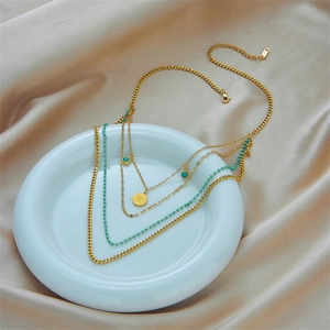 Collier multicouche en titane doré avec pendentif étoile et perles turquoise sur satin
