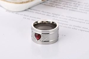 Macro detail of silver ring with heart-shaped red gemstone and white crystal accents