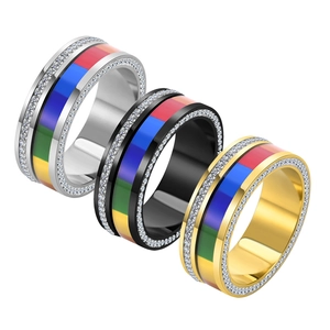 Macro shot of colorful enamel rainbow band and pavé set cubic zirconia on stainless steel rings