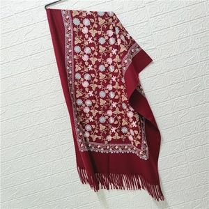 Detail of wine red faux cashmere shawl with floral embroidery and tassel fringe