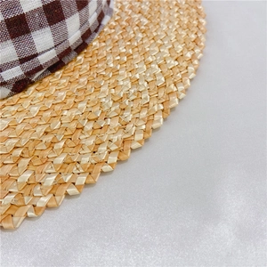 Détail du tissage en paille naturelle et ruban à carreaux sur bord de chapeau