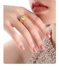 Dettaglio anello placcato oro a righe con zircone rettangolare su un dito femminile