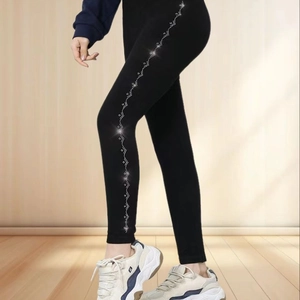Detail view of black thermal leggings featuring side rhinestone wave patterns and slim fit