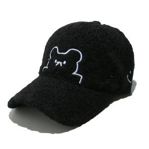 Detail of black fuzzy fleece baseball cap featuring white embroidered cartoon bear design