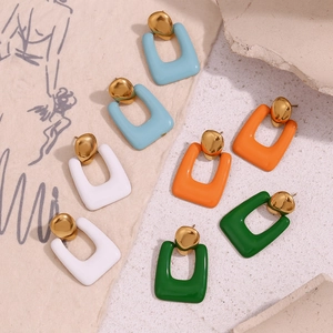 Detailed view of U-shaped enamel earrings in blue, white, orange and green colors