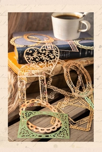 Close-up of vintage hollow lace paper frames for journaling on aged books background
