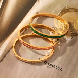 Three-piece gold plated open bangles with emerald, pink, and white cubic zirconia stones