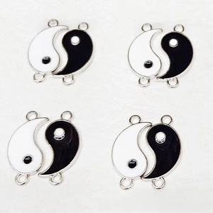Macro shot of Yin Yang enamel alloy charms for DIY jewelry making with two connecting loops