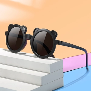 Cute bear-eared kids sunglasses with round lenses on a colorful geometric display