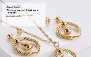 Macro shot of gold plated titanium steel jewelry set with woven ring and teardrop charms