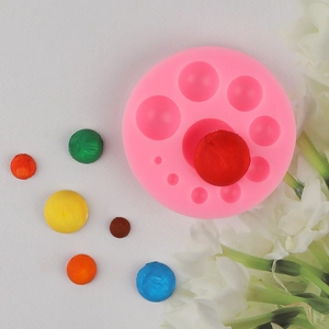 Pink silicone mold for round pearls with colorful chocolate ball samples for baking