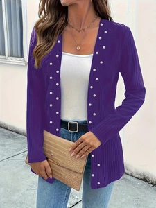 Detail of purple knitted cardigan featuring vertical stripes and white pearl embellishments