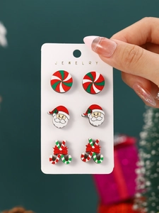 Detailed view of three pairs of wooden Christmas earrings featuring Santa and candy canes